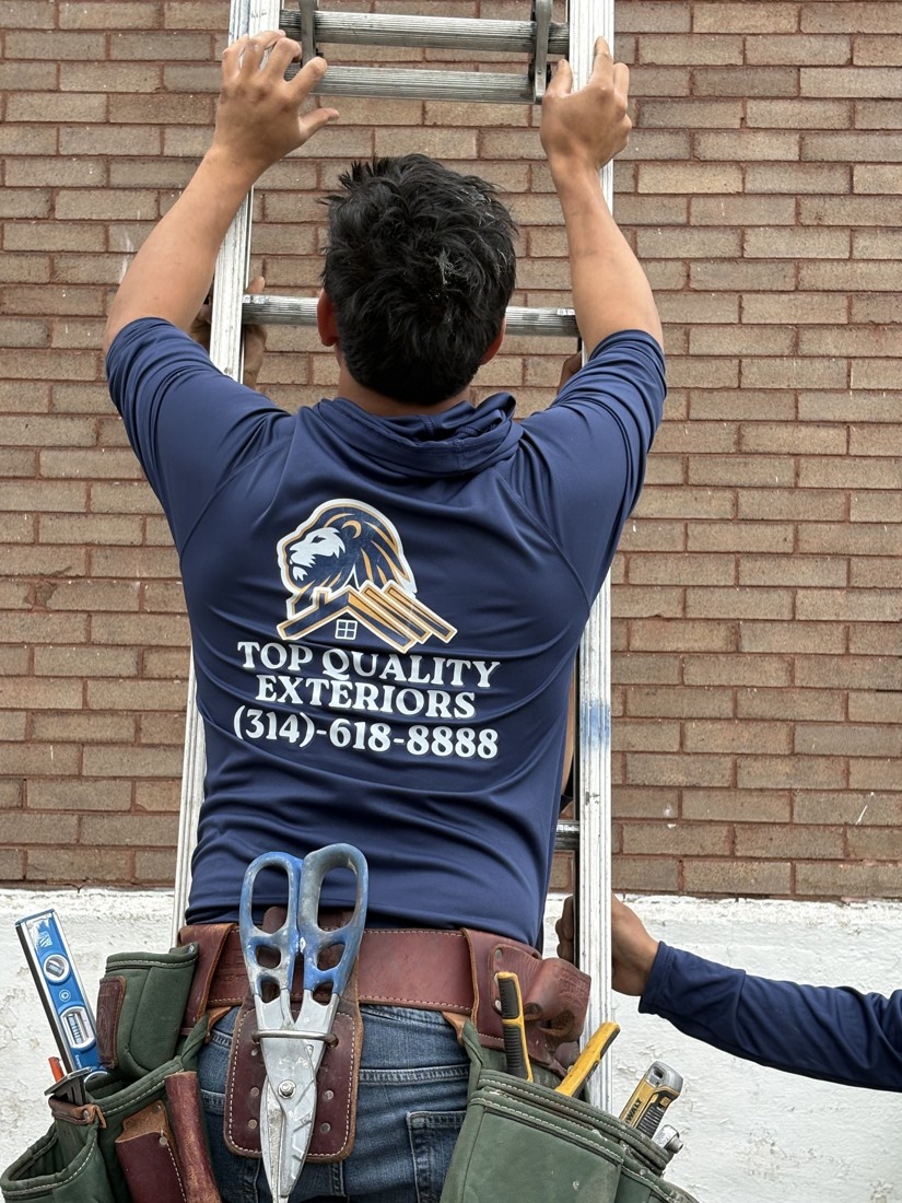 Crew member climbing a ladder to inspect a roof